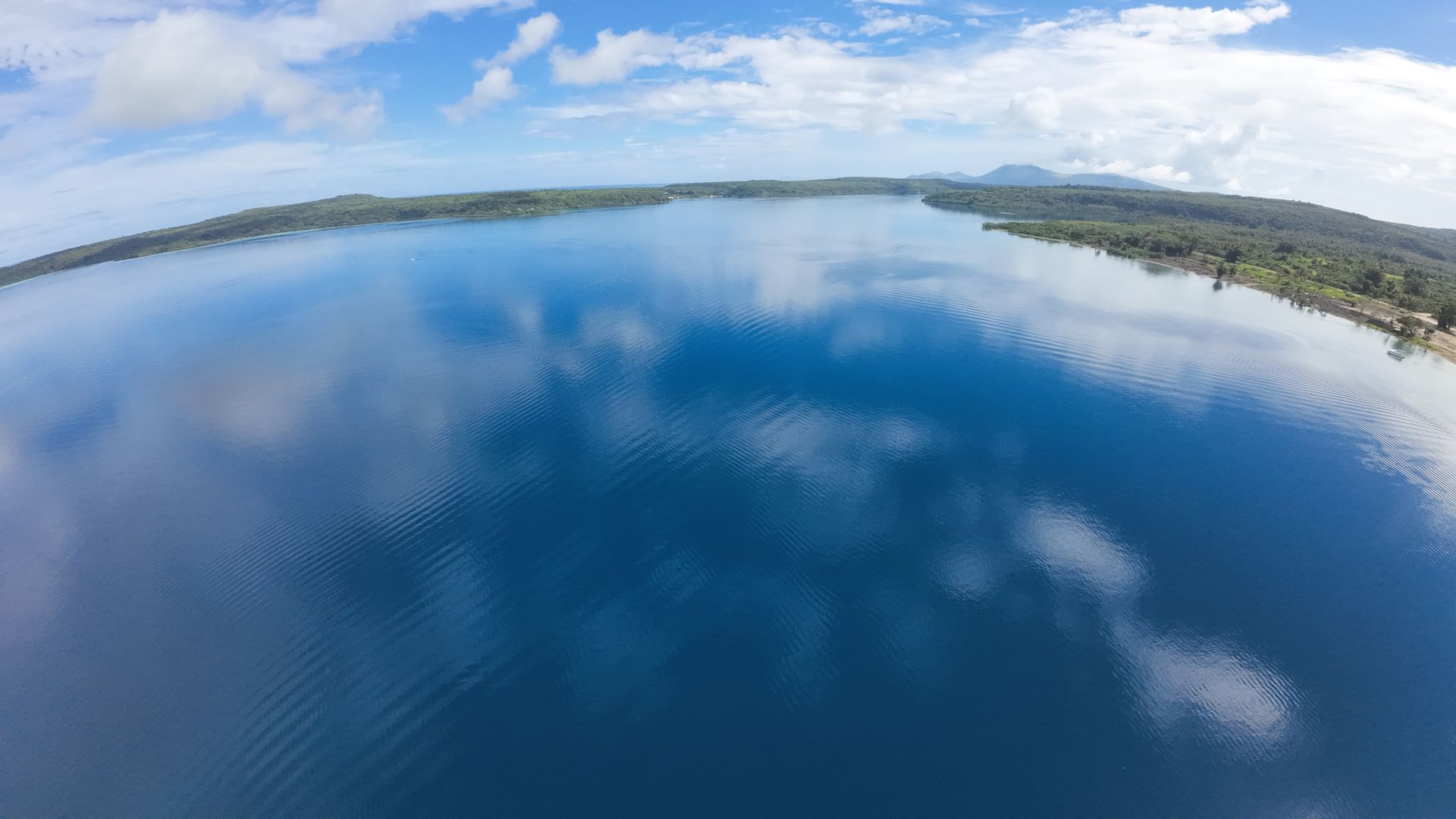 Vue de drone depuis le lot 118 sur les eaux calmes de Havannah Harbour vers l'île de Moso, avec les lots de la marina en front de mer le long du rivage à droite.